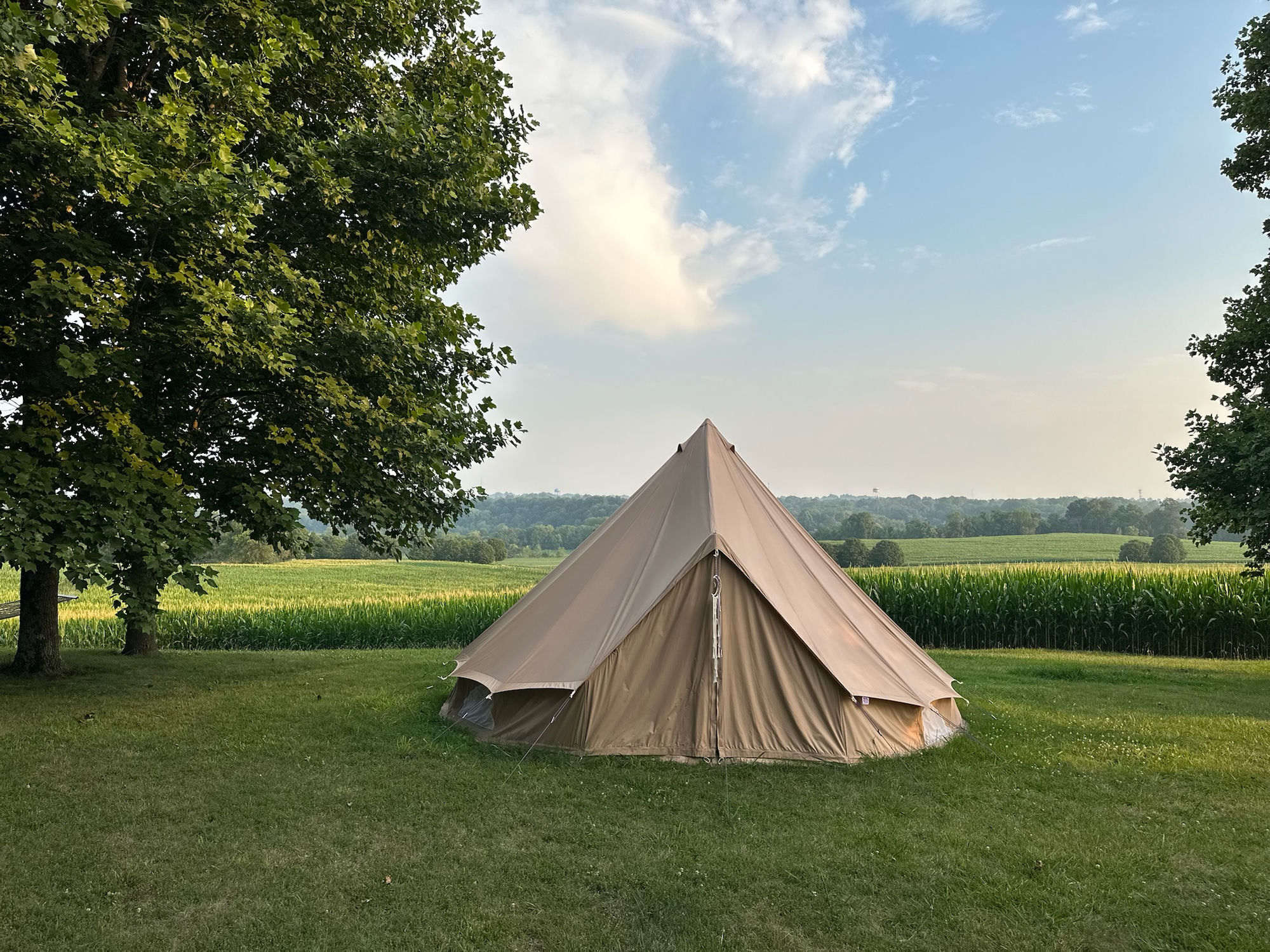 Bell tent set up in the farm field at sunset